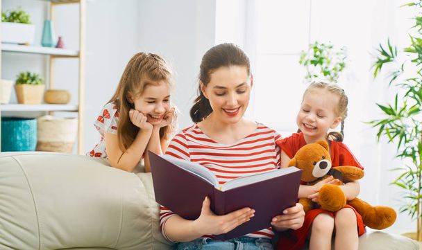 mother reading a book to daughters - Foto, Imagen