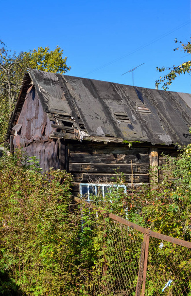 Oude instortende zwarte schuur met een lekkerig dak - Foto, afbeelding