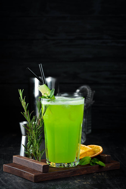 Cocktail Jungle Juice. Green Alcoholic Cocktail. On a wooden background. Top view. Free copy space. - Foto, Imagen