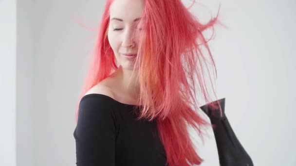 Concept of coloring and hair care. Young woman dries red hair on a white background - Záběry, video