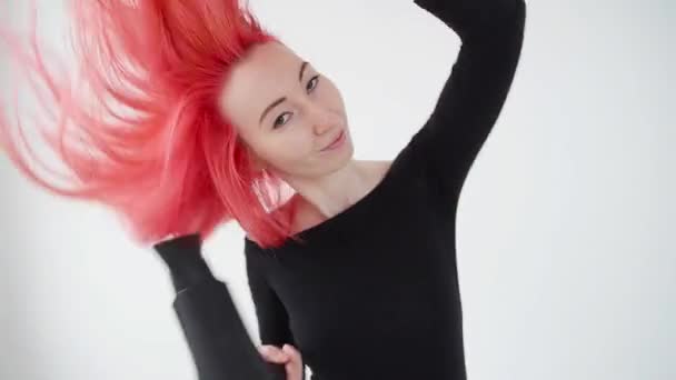 Concept of coloring and hair care. Young woman dries red hair on a white background - Video