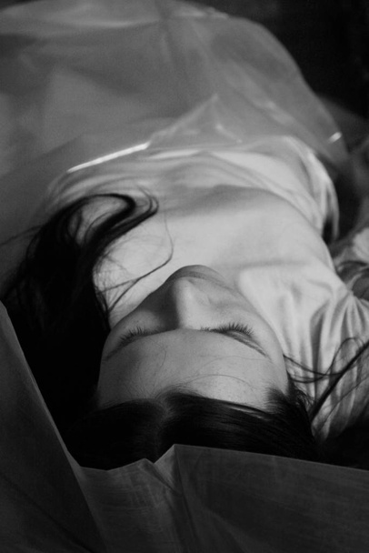 The dead beautiful girl lays in a cellophane bag - 写真・画像