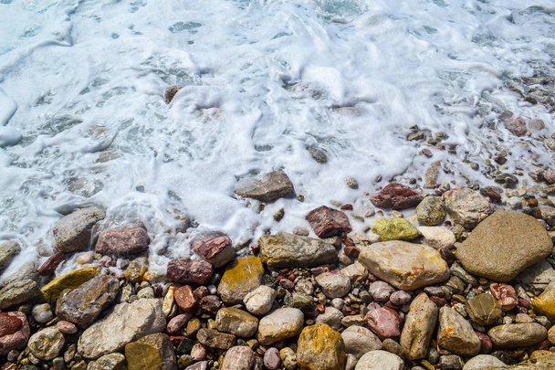 Zee golven, schuim van de zee, breken op de kust stenen. - Foto, afbeelding