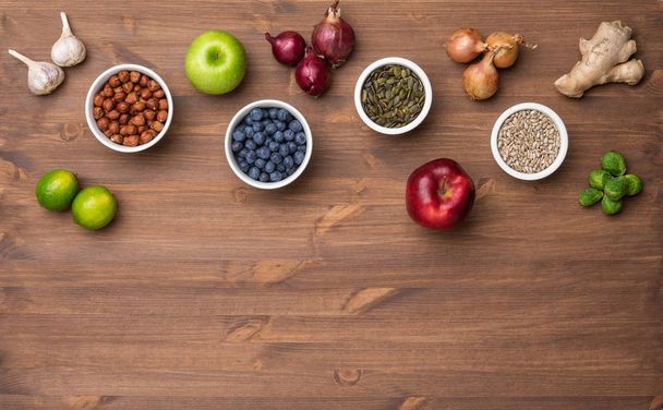 Healthy eating ingredients: fresh vegetables, fruits and superfood. Nutrition, diet, vegan food concept. Wooden background - Photo, Image
