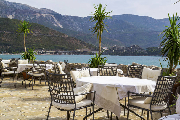 Restaurace v otevřeném vzduchu nedaleko moře. Stoly a židle na  - Fotografie, Obrázek