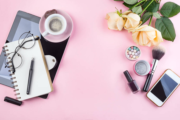 Estilizado flatlay femenino con taza de café, rosas flor, gafas y tableta maqueta aislado en rosa vista superior. Accesorios mujer desde arriba espacio de copia para texto
 - Foto, Imagen