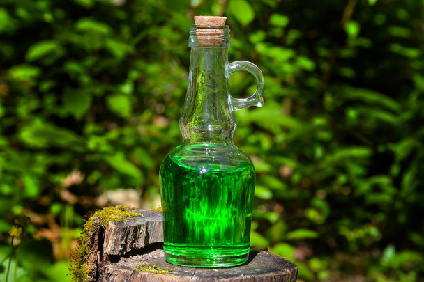 Bouteille avec liquide vert sur la souche
 - Photo, image