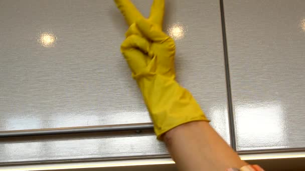 Ο καθαρισμός του σπιτιού της άνοιξης ολοκληρώνεται και το χέρι της γυναίκας σε κίτρινο λαστιχένιο γάντι δείχνει χαρούμενες αστείες χειρονομίες νίκης στο φόντο των καθαρών ντουλαπιών κουζίνας - Πλάνα, βίντεο