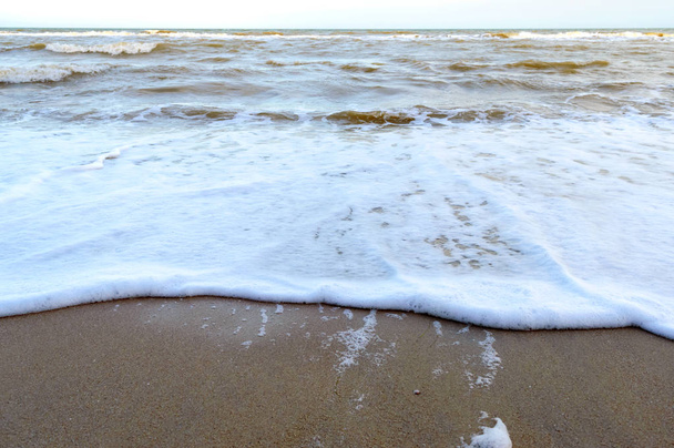 Vlny na břehu. Mořská vlna se nachází na písečné pláži s slunečním zářením. - Fotografie, Obrázek