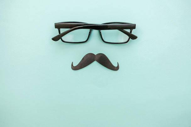幸福な父の日の概念。パステルブルーの背景上に隔離された眼鏡で口ひげのサイン。マンシルエットシンボル - 写真・画像