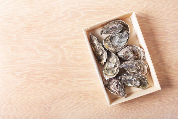 Closed oysters on wooden background. Healthy sea food. Copy space, top view - Photo, image