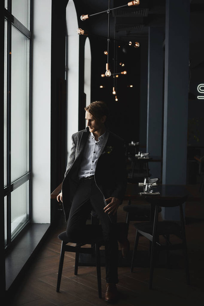 Stylish handsome businessman in fashionable coat at restaurant interior - Foto, immagini