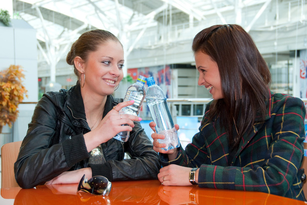 dwie dziewczyny pić wody w żywności sądu - Zdjęcie, obraz