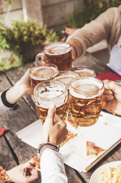 group of happy friends drinking beer and eating take away pizza - Foto, Bild