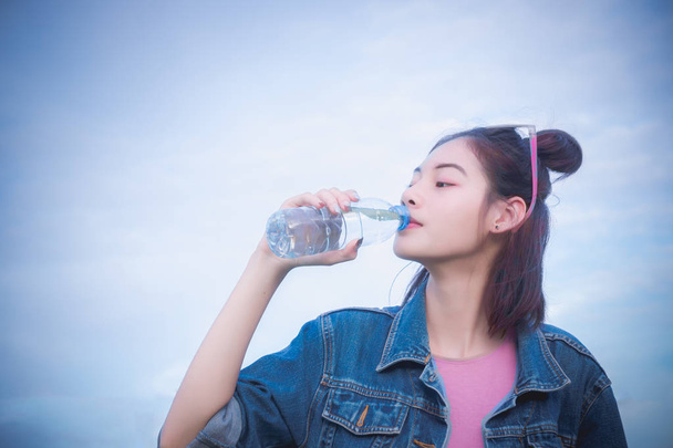 υγιή κοριτσιού πόσιμο νερό στο μπουκάλι, ποτό για διψασμένα για αναζωογονητικό - Φωτογραφία, εικόνα