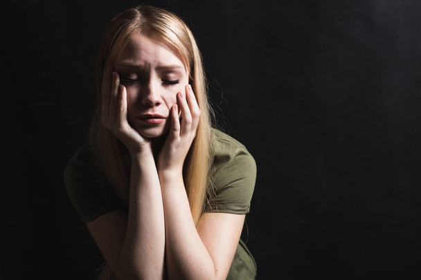 Surullinen nuori nainen tulee itkemään mustalla taustalla
 - Valokuva, kuva