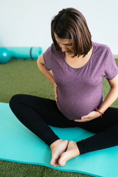 Pregnant woman doing fitness ball and pilates exercise with coac - Photo, Image