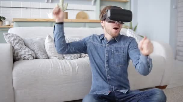 Joven emocionado con auriculares de realidad virtual tocando en la batería de aire VR 360 videojuego en casa
 - Imágenes, Vídeo