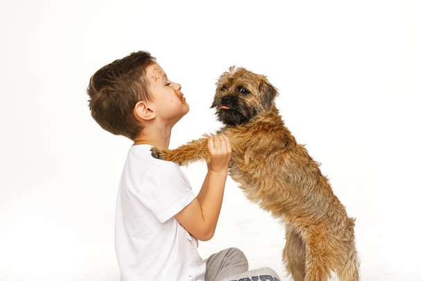 Pieni poika suklaassa koiransa kanssa
 - Valokuva, kuva