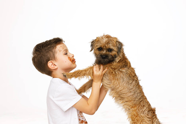 little boy in chocolate with his dog - Valokuva, kuva