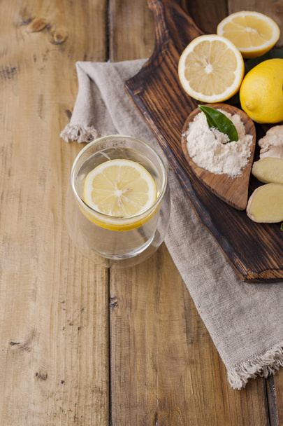 ginger, lemon and glass on a wooden background, Photo in rustic  - Foto, imagen