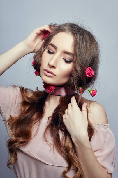 Beautiful woman with rose flowers in her long hair, a bandage ar - Foto, afbeelding
