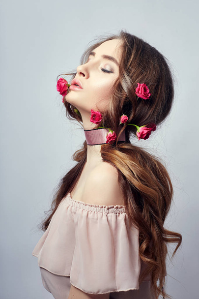 Beautiful woman with rose flowers in her long hair, a bandage ar - Fotó, kép