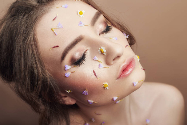 Flower petals on face girl, woman cosmetics to moisturize face s - Foto, afbeelding