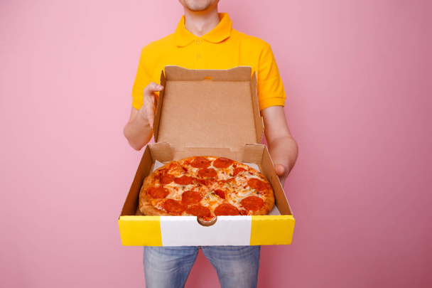 Zdjęcie kuriera z pudełkiem z pizzą w rękach . - Zdjęcie, obraz