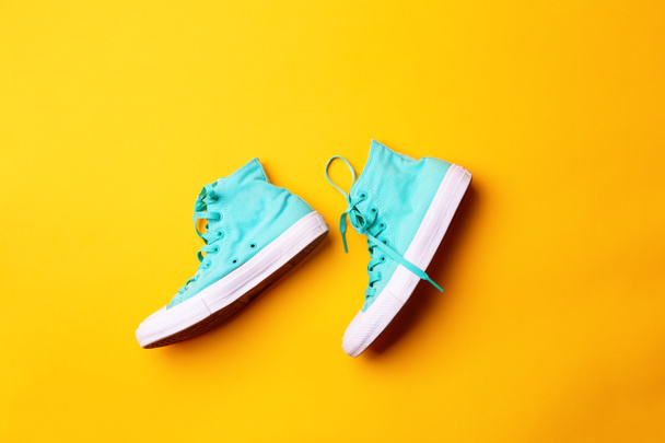 Pair of stylish sneakers laing on yellow background - Photo, Image