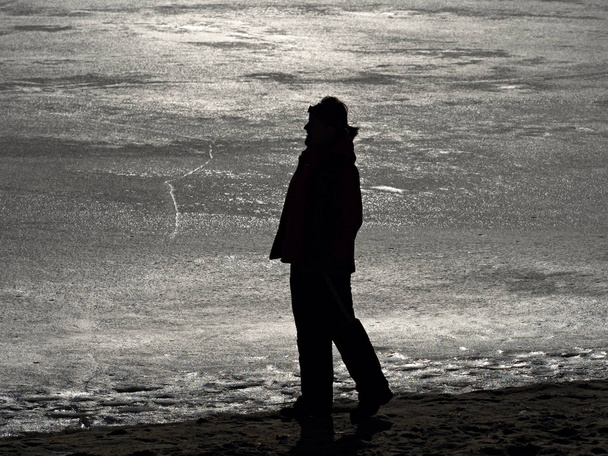 Mujer en ropa de abrigo disfrutar tomando el sol en el lago congelado
.  - Foto, imagen