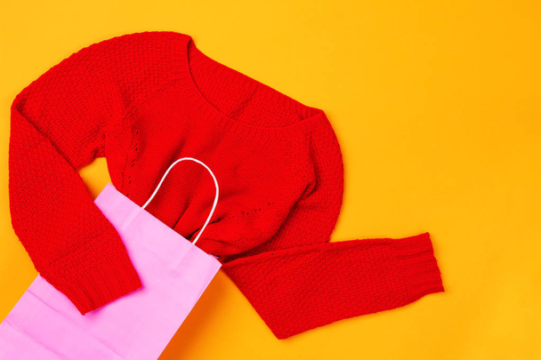 Вид сверху розовой сумки с красным свитером
 - Фото, изображение