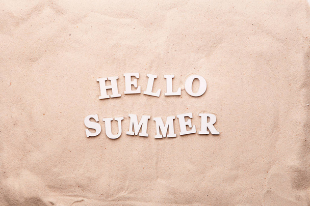 Tekst Hello Summer van witte letters op zand. - Foto, afbeelding