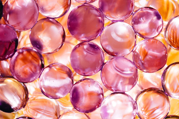 Αφηρημένο φόντο με γυαλιστερές μπάλες νερού σε βιολετί και πορτοκαλί χρώματα - Φωτογραφία, εικόνα
