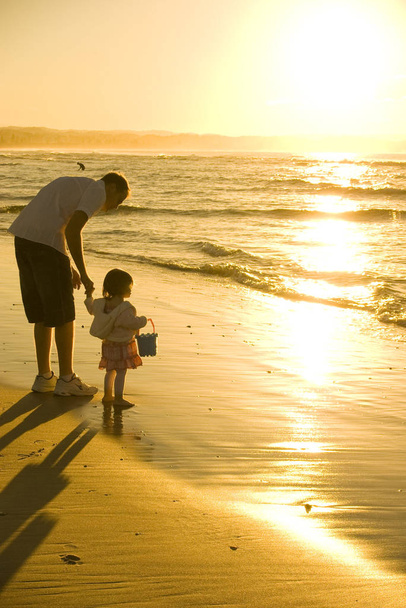 Father and Daughter playing at the beach - Fotoğraf, Görsel