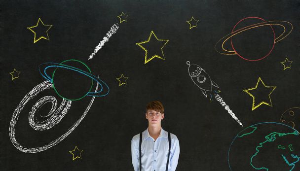 Businessman with chalk universe planet solar system on blackboard imagining space travel - Фото, изображение