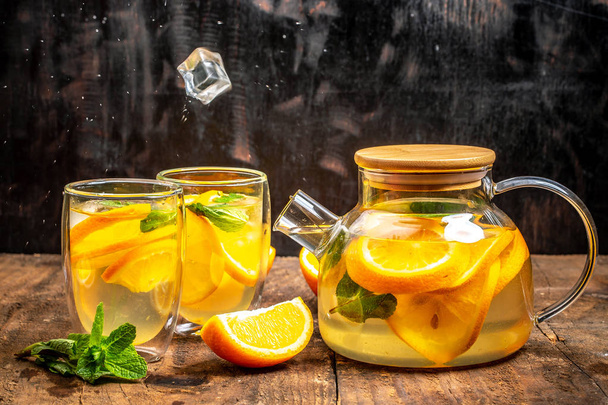 Orange detox water in mason jars on a wooden table. Healthy food, drinks, fitness, healthy nutrition diet concept - Fotó, kép