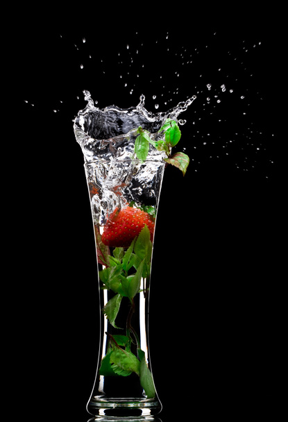 View of soft drink splashing out of glass on black back - Zdjęcie, obraz
