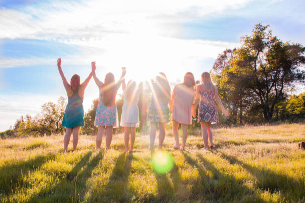 Skupina dívek stojí s zvedl ruce a slunce nad hlavou - Fotografie, Obrázek