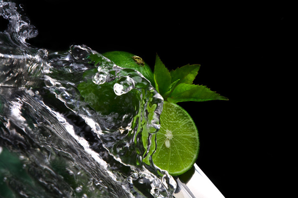 Close up view of fresh limes getting splashed by water - Фото, зображення