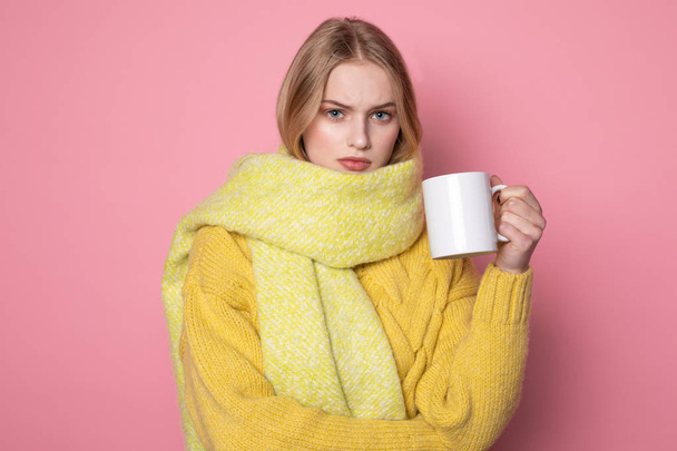 Beautiful sensual girl with blonde hair and blue eyes wearing yellow sweater and scarf - Foto, Imagen