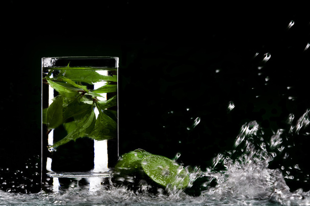 weergave van glas gevuld met groene thee en sommige limoenen opzij - Foto, afbeelding