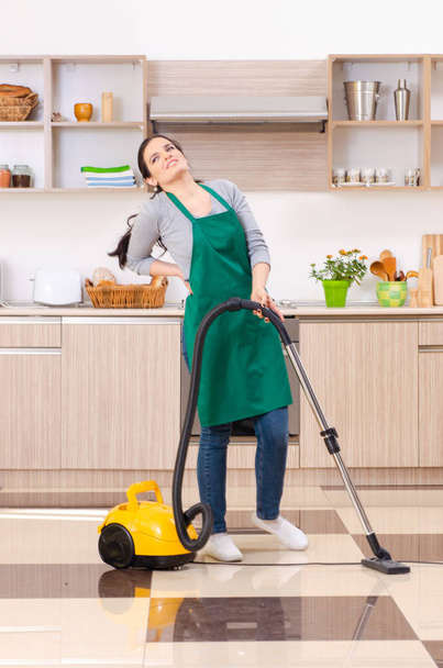 Jonge vrouwelijke aannemer doet huishoudelijk werk  - Foto, afbeelding