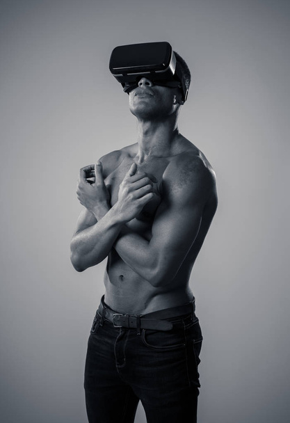 Attractive powerful african american man using augmented or VR goggles exploring new 3d world. Advertising of the power of virtual reality and augmented reality technology. 360 degree VR experiences. - 写真・画像