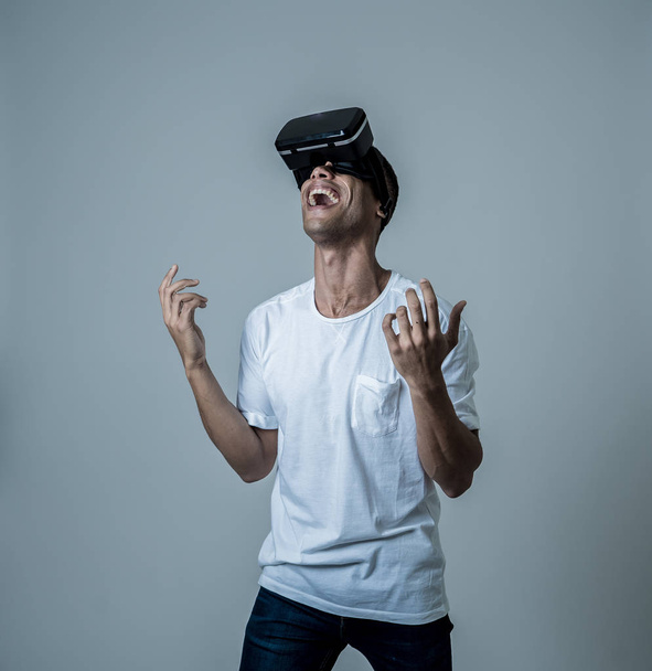 Incroyable homme afro-américain utilisant des lunettes de casque VR, se sentant excité par la simulation, explorer la réalité virtuelle faire des gestes interagissant avec un nouveau monde virtuel. Dans le concept des nouvelles technologies
. - Photo, image