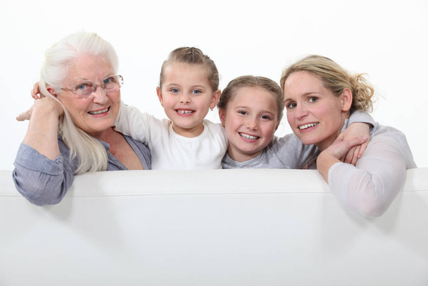 Grandmother, mother and daughters behind white sign - Foto, Bild
