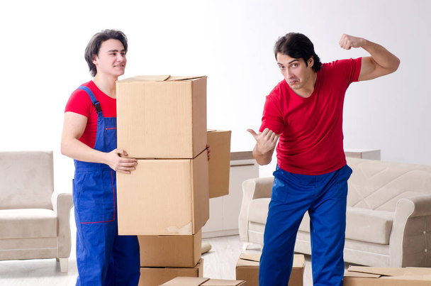 Twee jonge aannemers verplaatsen persoonlijke bezittingen - Foto, afbeelding