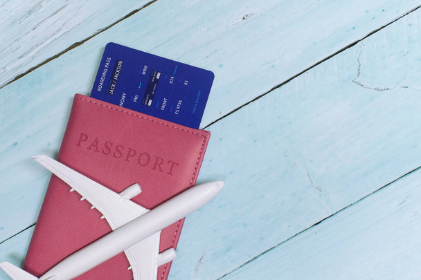 Time to Travel. Idea for tourism with an airplane, passport and tickets on the blue wooden background. - Photo, Image