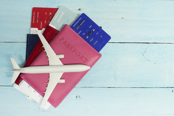 Time to Travel. Idea for tourism with an airplane, passport and tickets on the blue wooden background. - Fotografie, Obrázek