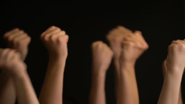 Raising hands with fists on black background. - Footage, Video